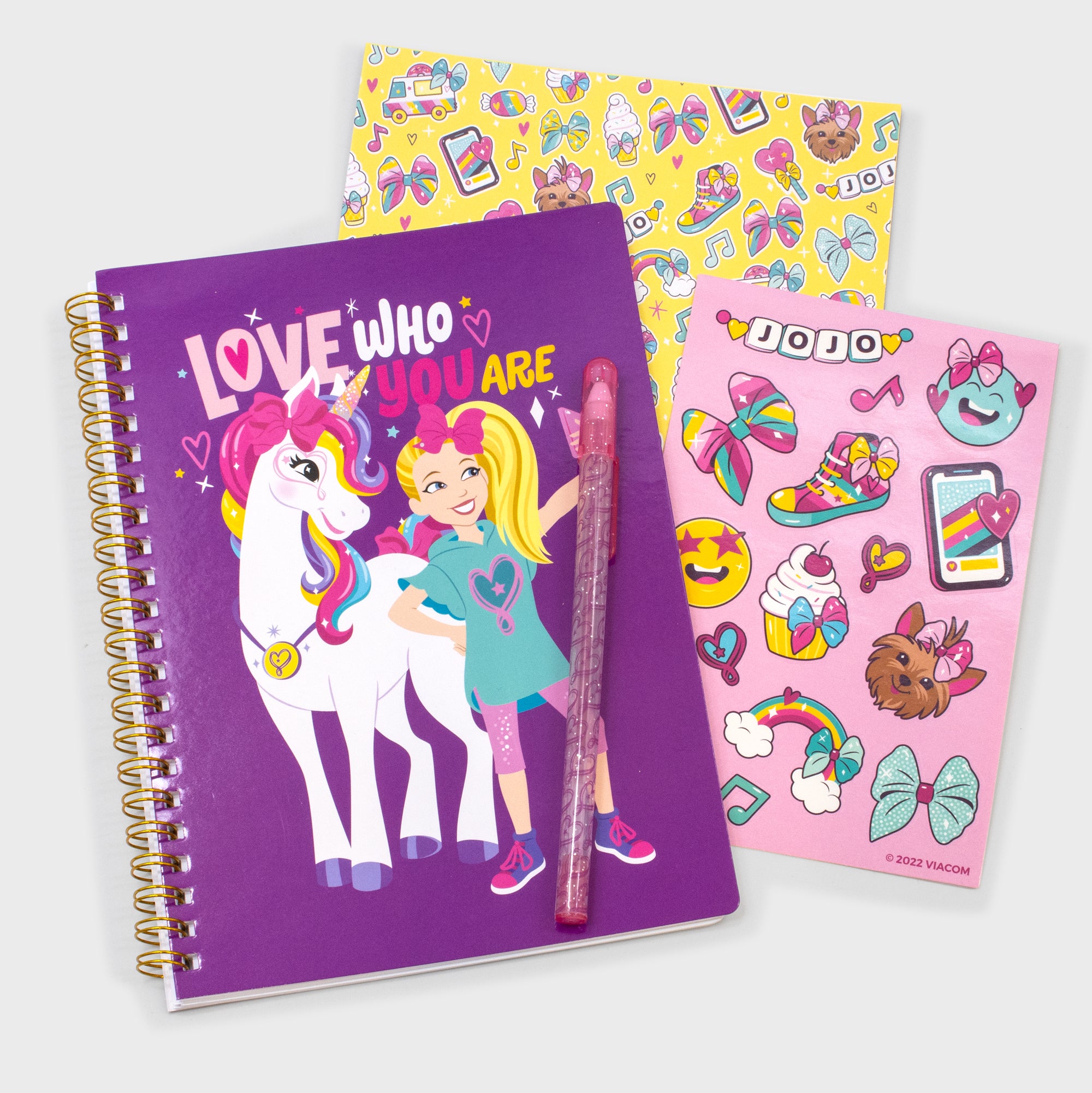 jojo siwa scrapbook set. includes: notebook, stickers, craft paper, pen. image on notebook: jojo with unicorn. text: love who you are. stickers: smiley face, phone, sneaker, bow, bowbow, cupcake, rainbow, letters that say jojo. craft paper: phone, ice cream truck, ice cream cone, bows, sneakers, letters that say jojo, bowbow.