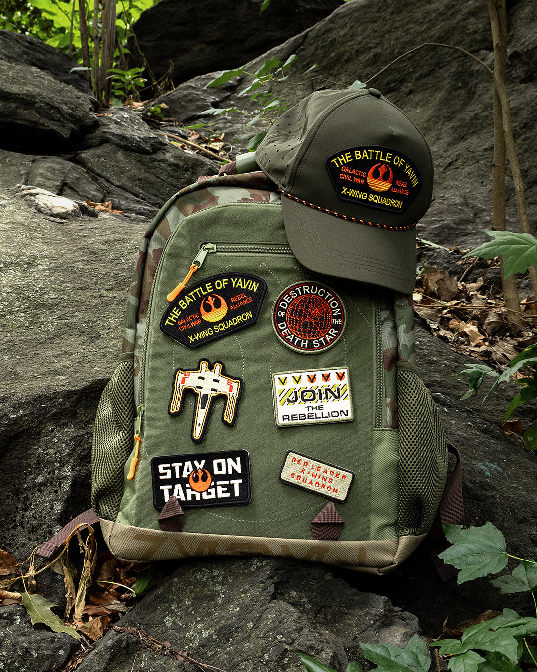 Green backpack with patches on a rocky surface