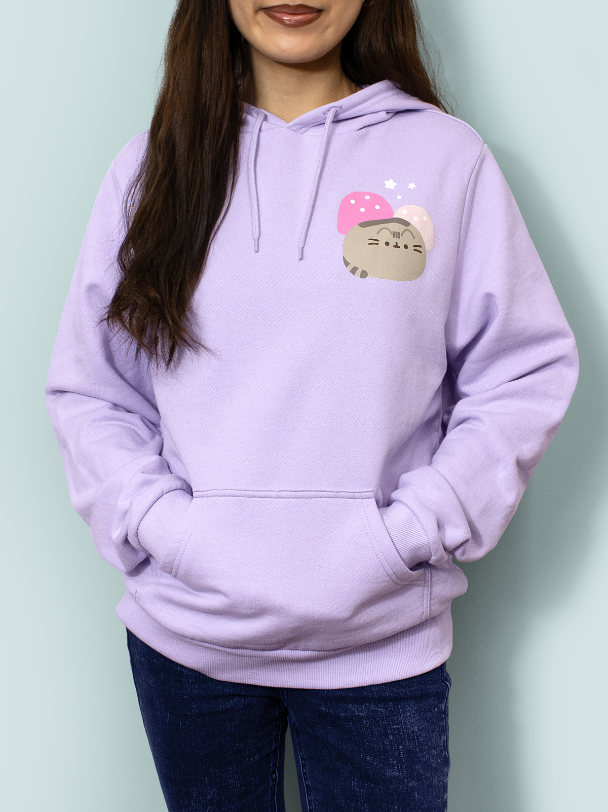 Person wearing a lavender hoodie with a cartoon character design on a light green background