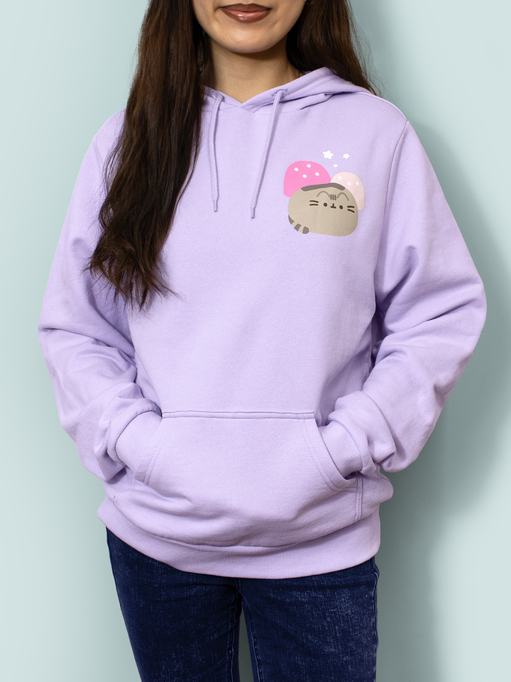 Person wearing a lavender hoodie with a cartoon character design on a light green background