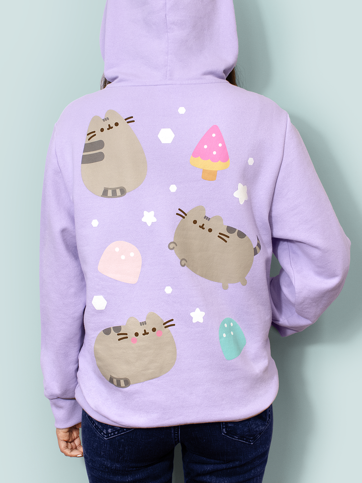 Person wearing a lavender hoodie with cartoon cat designs on a light blue background