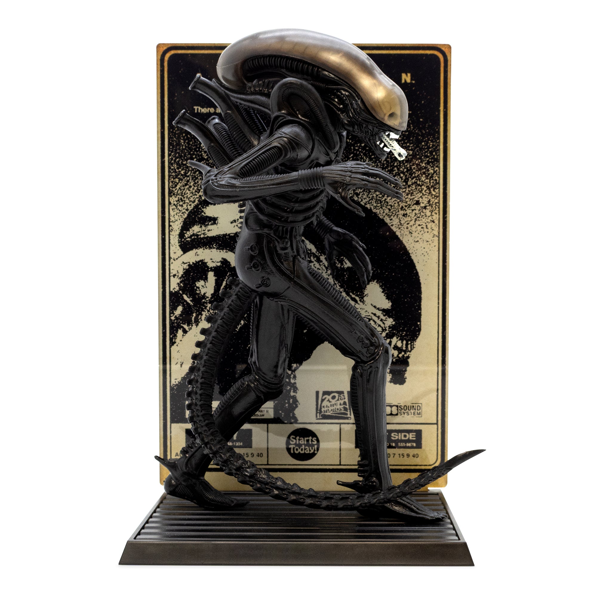 Black alien figure on a stand with a branded box in the background