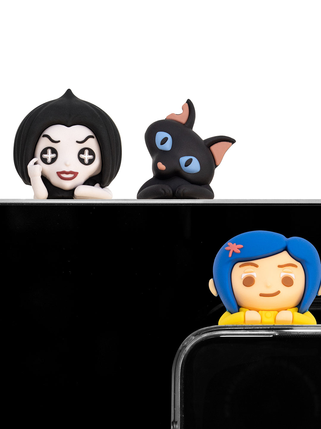 Three small character figurines displayed on a black surface against a white background: a black-haired pale face figure, a black cat with blue eyes, and a blue-haired girl figure with a yellow top peeking over a black phone or frame.