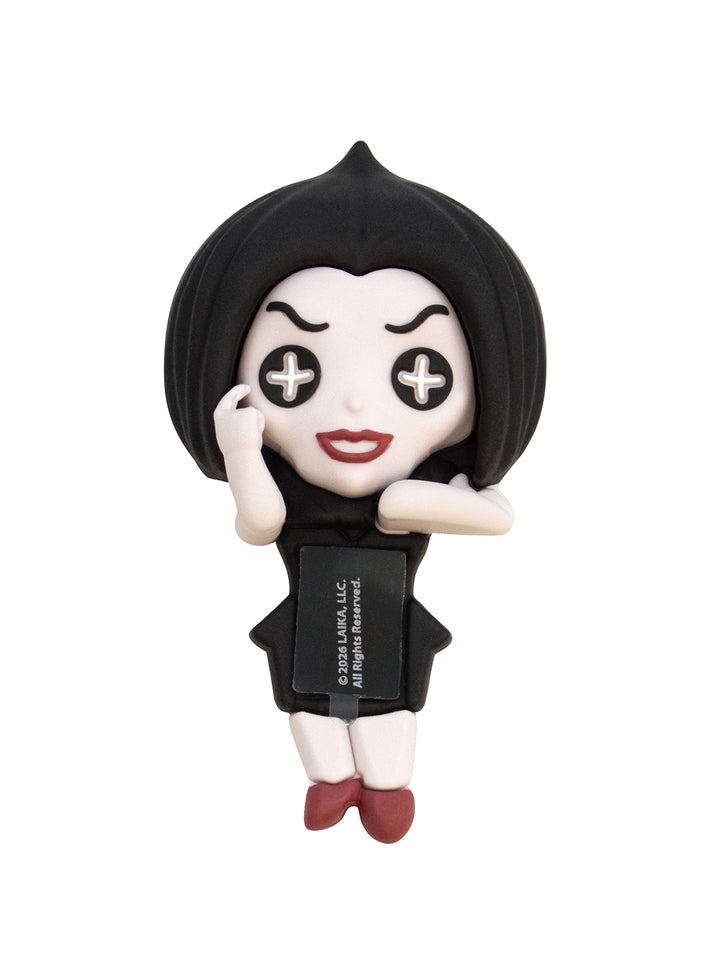 A stylized chibi figurine of a woman with short black hair, a black dress, and red shoes, posed with her hands near her face on a plain white background. A small black tag is attached to the dress with white text.