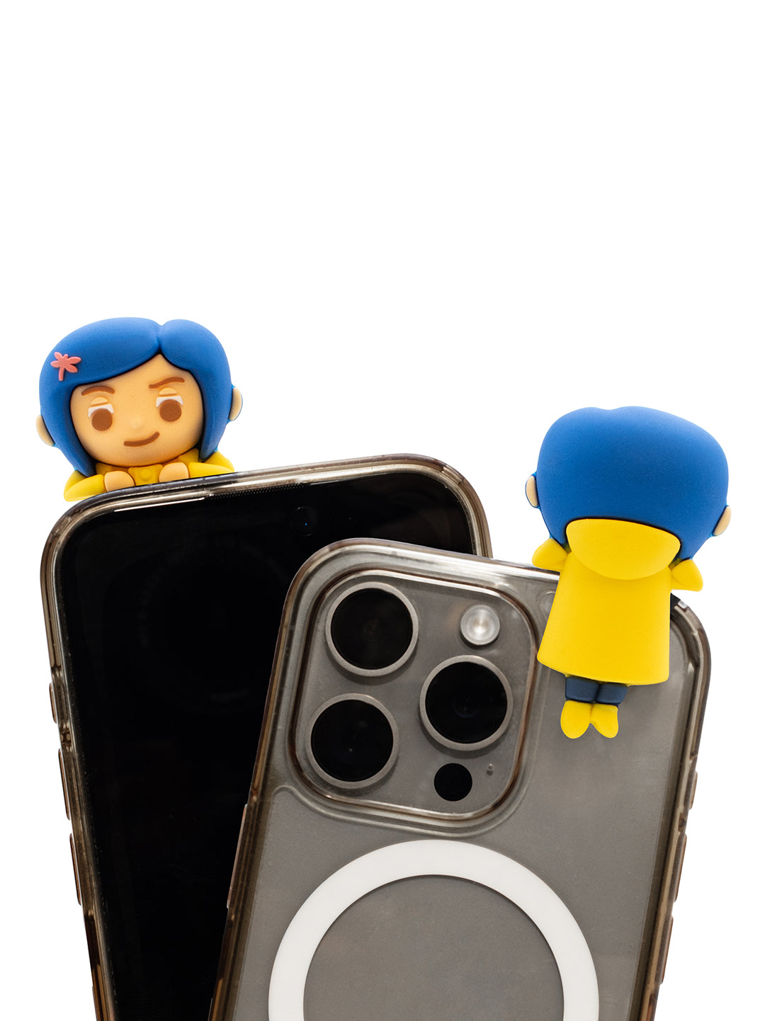 Two small cartoon phone charms with blue hair and yellow tops are shown attached to the top edges of two smartphones on a plain white background.