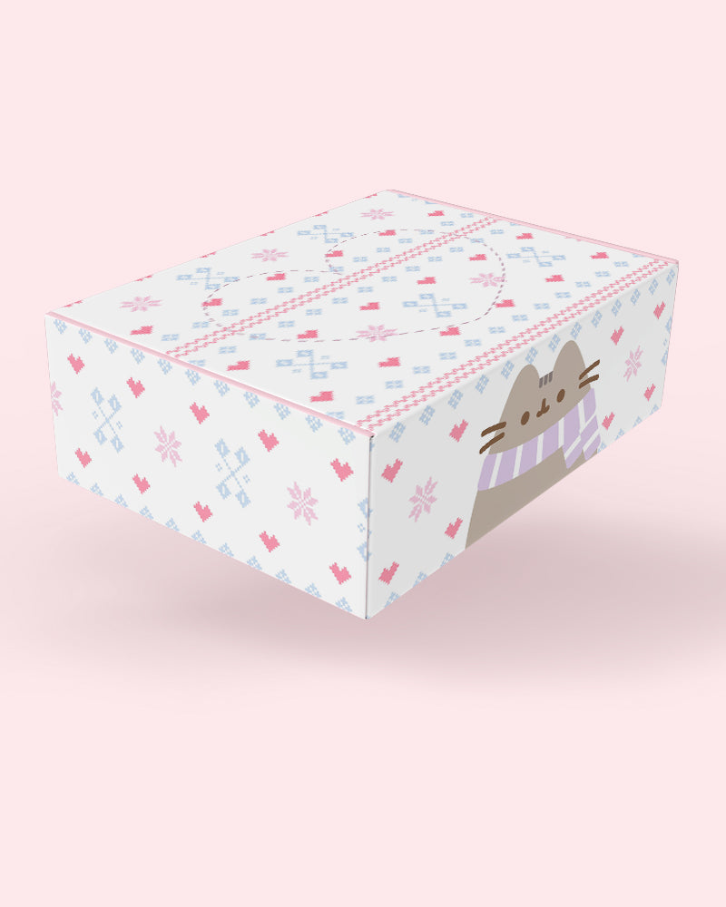A square gift box featuring a white background with a pink and light blue geometric pattern, decorated with a cartoon cat face wearing a striped scarf on the front.