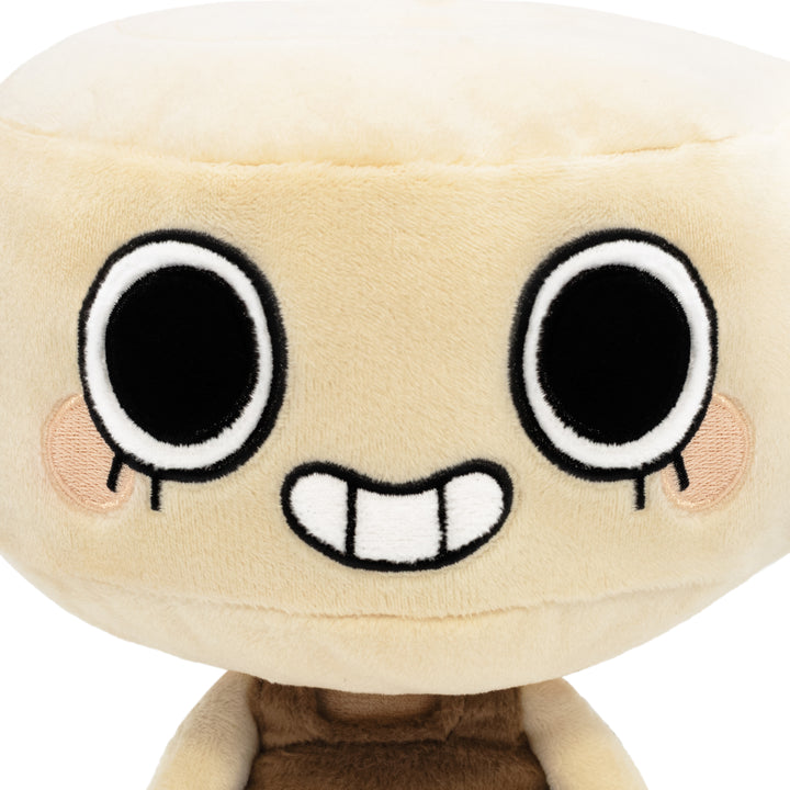 shelly plush close up view. cartoon plushie with brown shirt on. head shaped like a shell. smiling face.