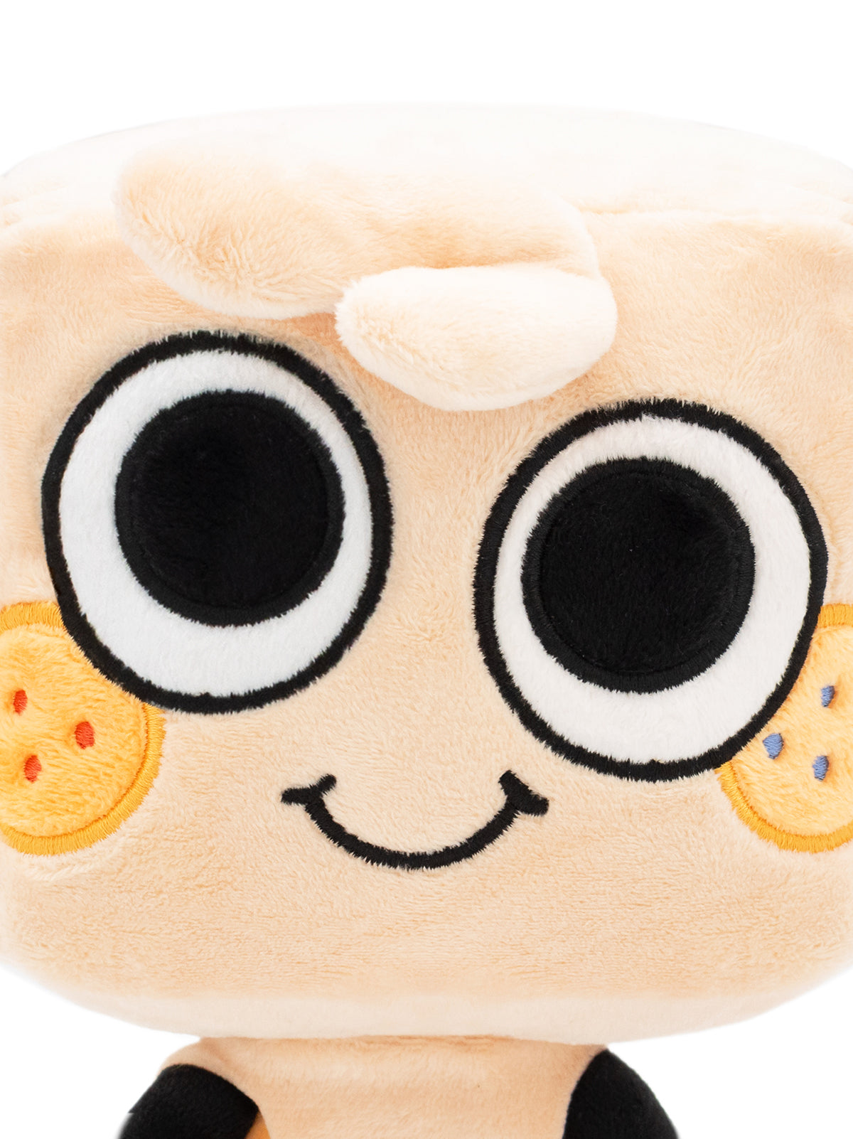 Close up of Goob plush face. Two eyes, two cheek spots, curl of hair, smile