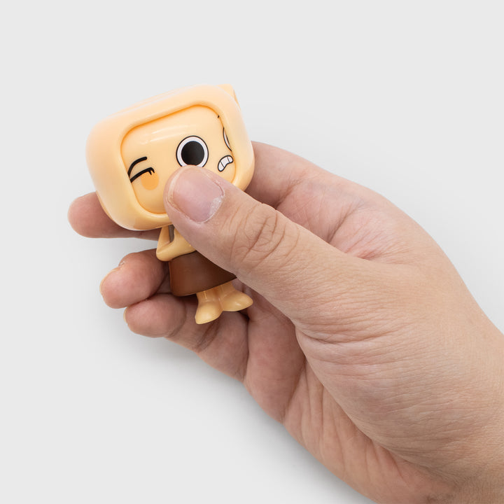 Hand holding a small figurine with a sad expression on a white background