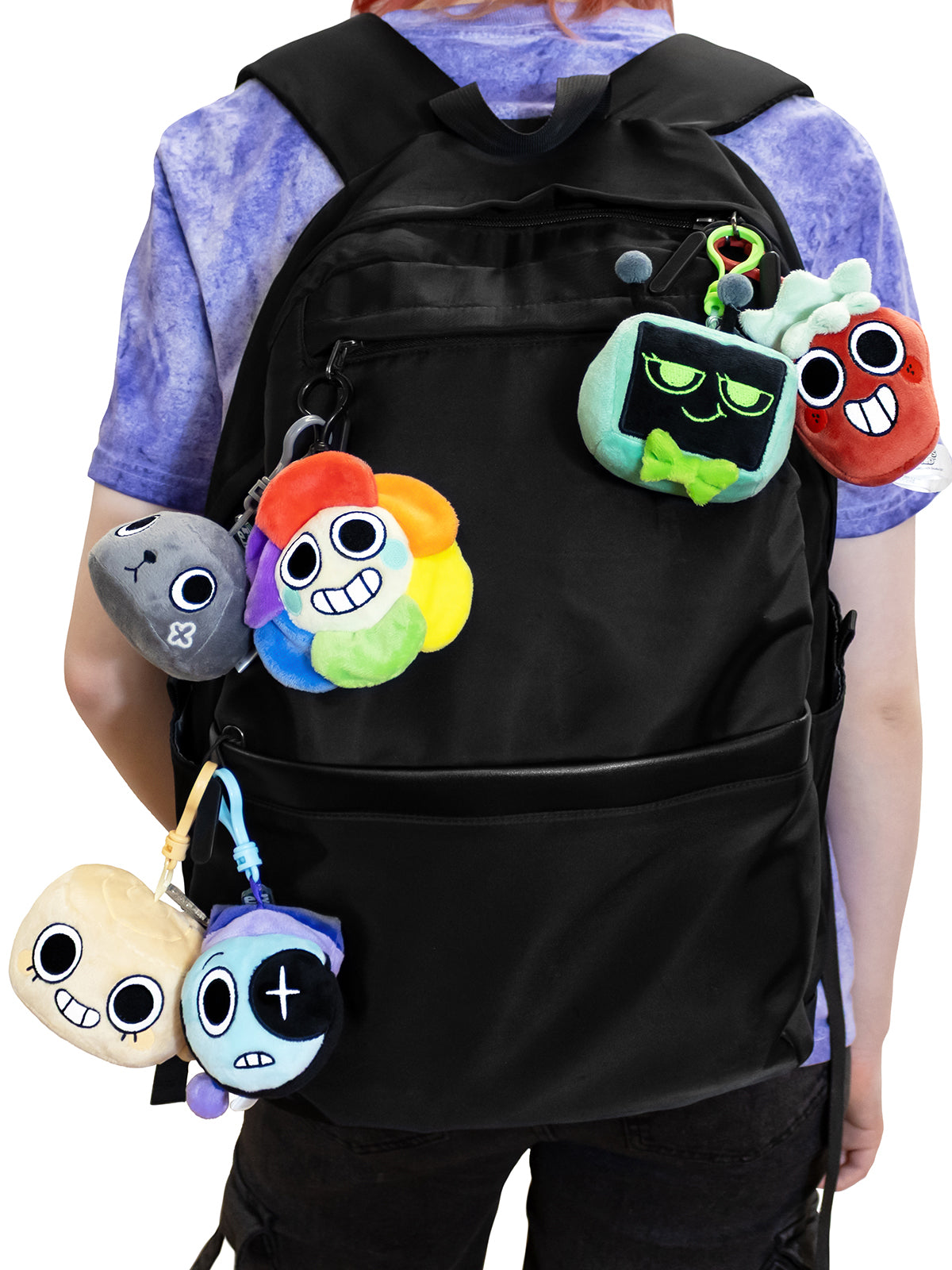 Person wearing a black backpack with colorful plush keychains attached