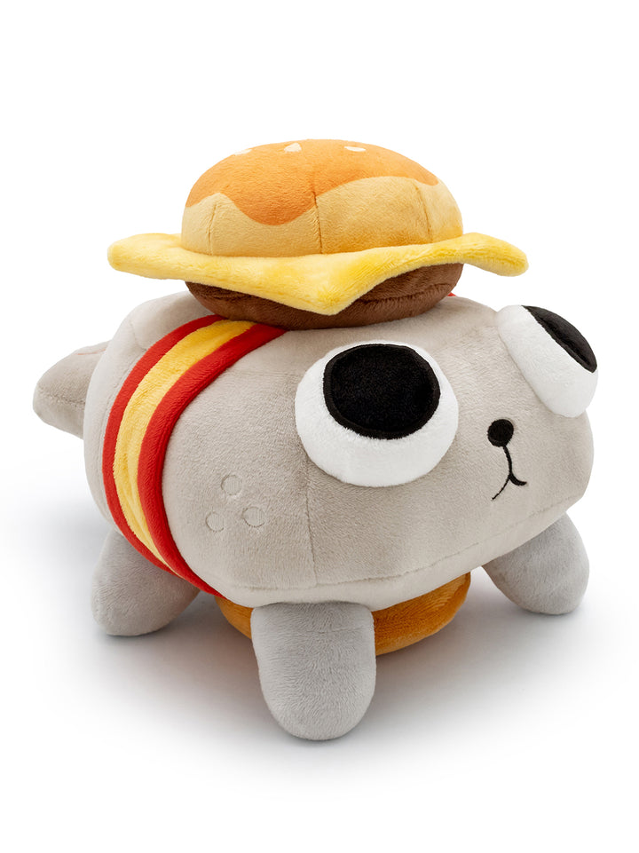 Pebble plush with cheese burger on his head and bottom. facing right.
