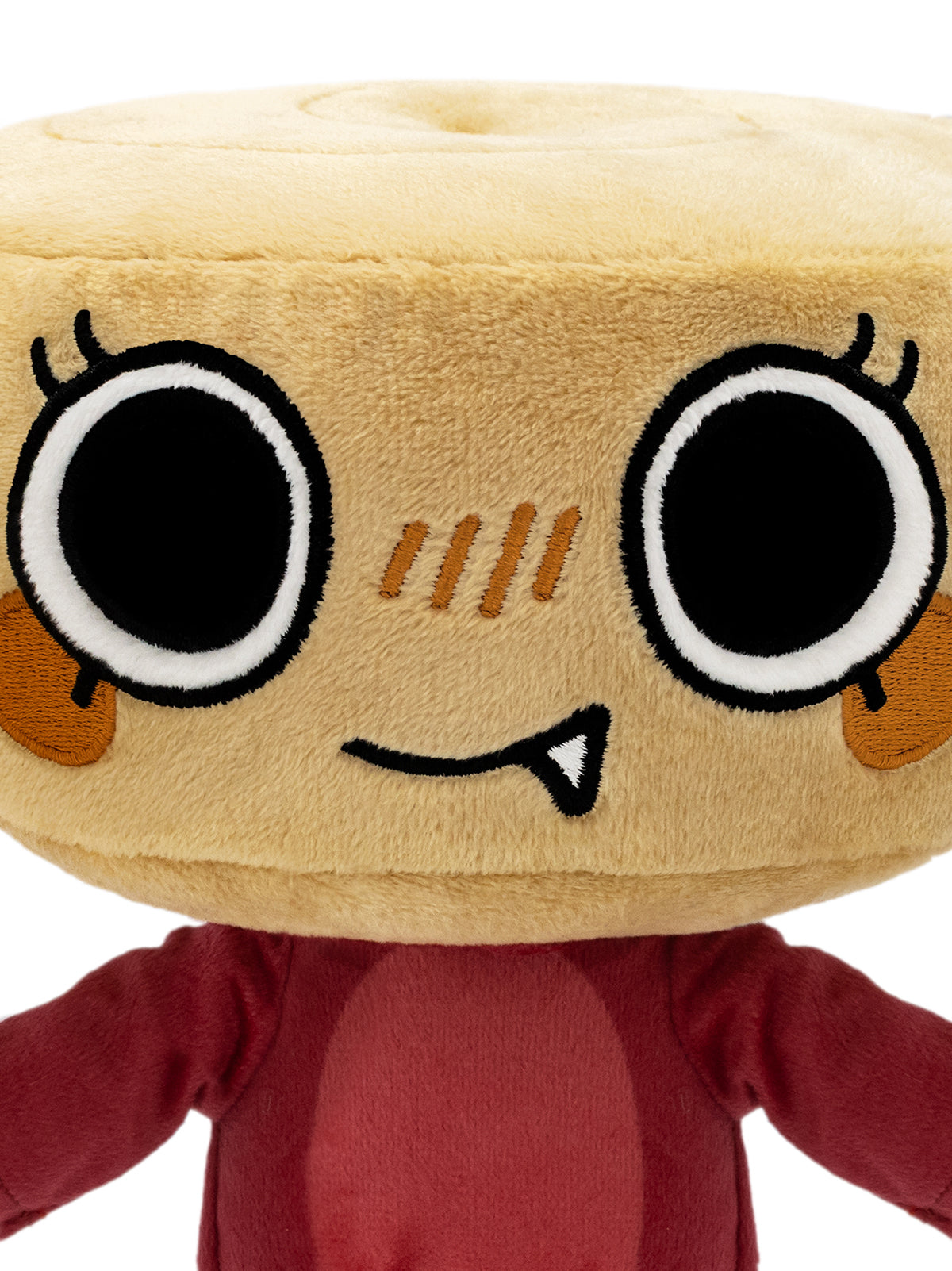 A close-up of a plush toy with a round beige head resembling a bread roll, featuring large cartoon eyes, embroidered facial details, and a dark red body.