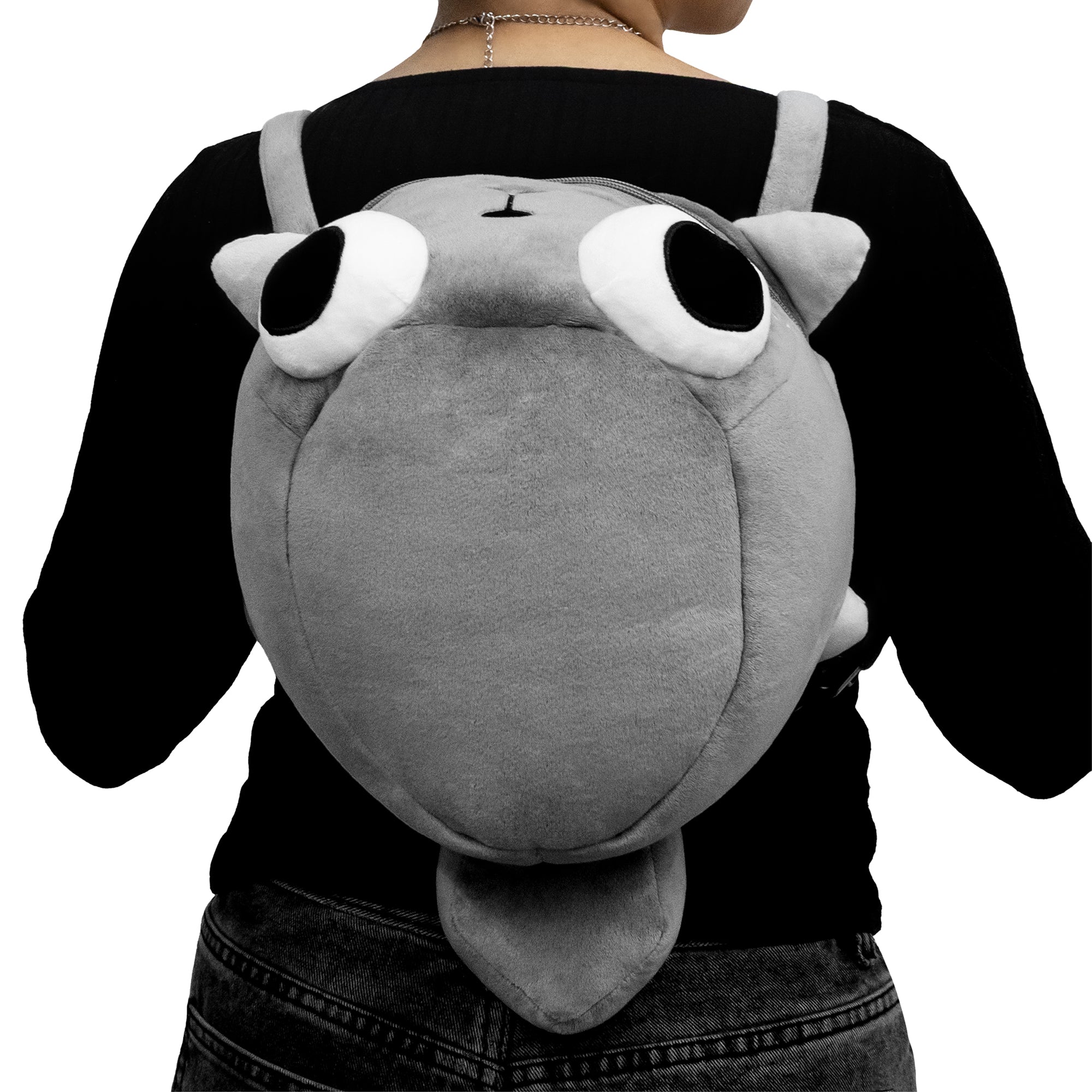Person wearing a plush backpack shaped like a cartoonish creature with large eyes.