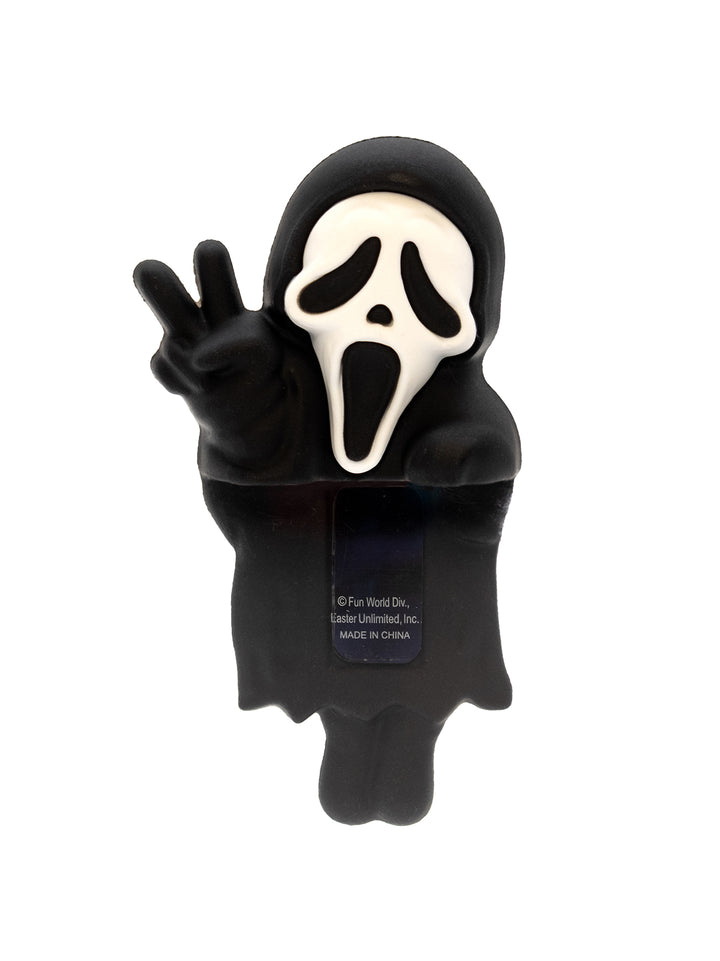 Character in a black hooded outfit with a white face, making a peace sign on a white background.