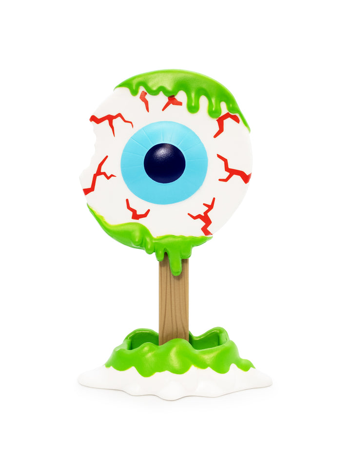 A figure shaped like a creepy melting eyeball on a wooden stick, with green slime dripping from the top and bottom, red veins, and a white base on a white background.