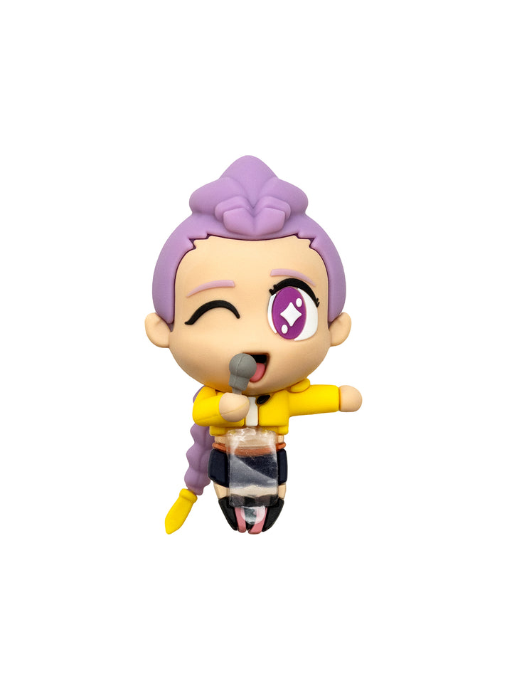 A chibi-style collectible figurine of a winking character with purple hair, wearing a yellow top and holding a microphone, isolated on a white background.