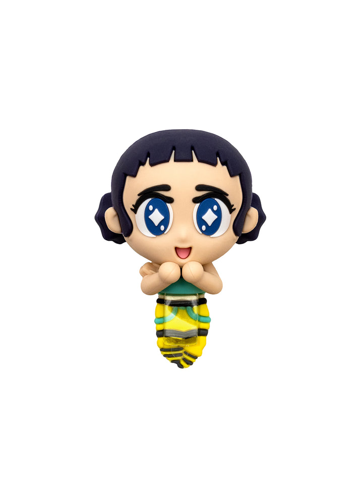 A small chibi-style collectible figure of a girl with short dark hair, large blue eyes, and a green-and-yellow striped skirt, shown against a plain white background.