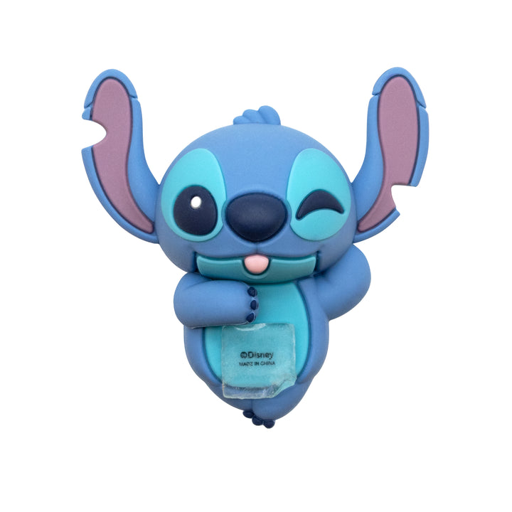 A blue cartoon character accessory featuring Stitch-like eyes, large pink-tinted ears, a winking expression, and a small clear pouch held in front, shown on a plain white background. Disney text is visible on the pouch.