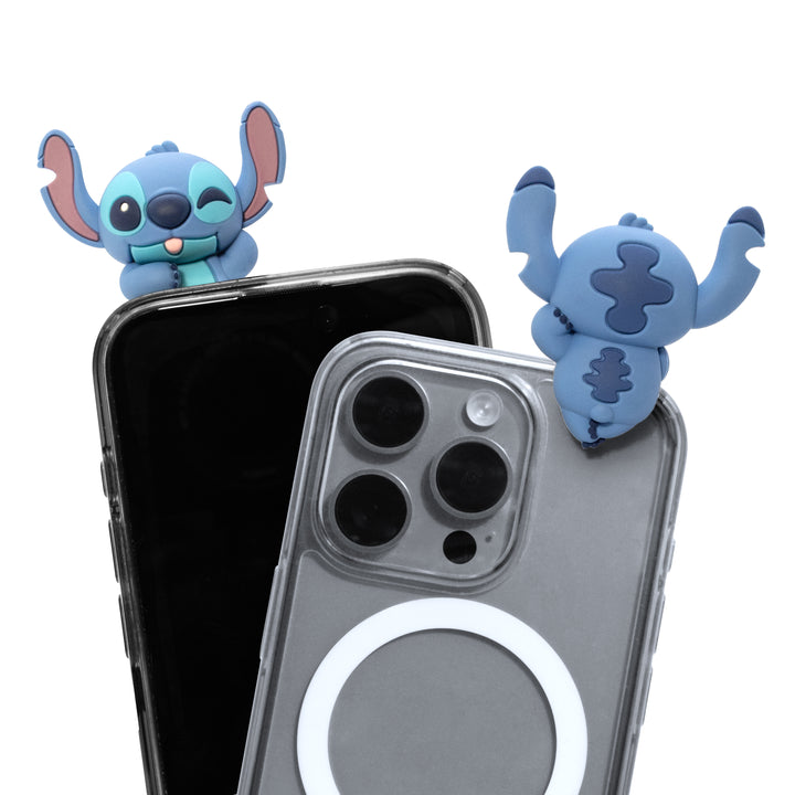 Two blue cartoon character phone accessories with large ears are shown attached to the top of two smartphones, one black and one gray, on a plain white background.