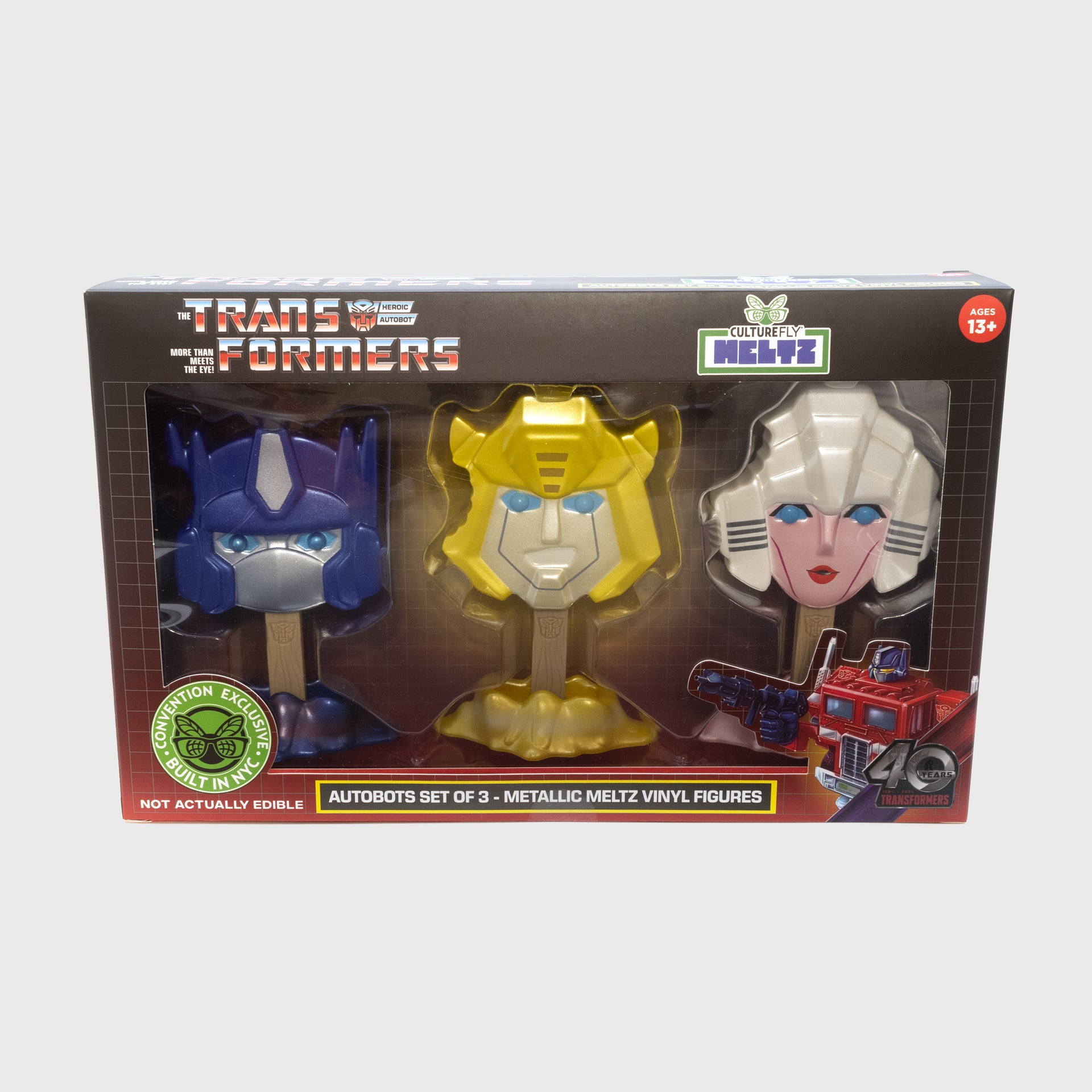 front of 3-pack packaging. showing all 3 meltz. text: the transformers heroic autobot more than meets the eye! culturefly meltz. ages 13+. not actually edible. convention exclusive built in nyc. autobots set of 3 - metallic meltz vinyl figures. 40 years transformers.