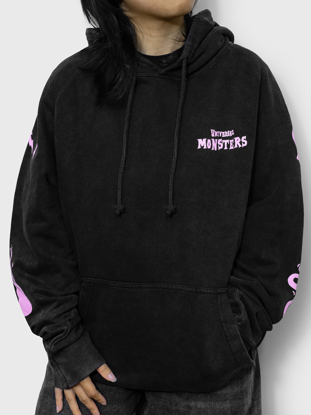 front of hoodie on model. front pocket. adjustable hood. universal monsters on left pocket.