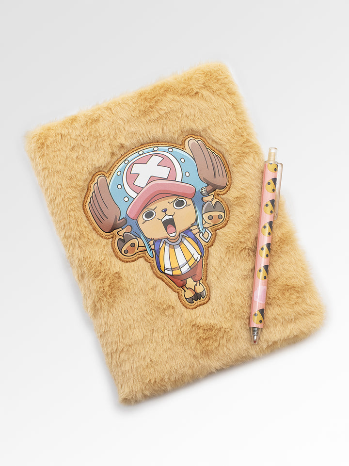 Fluffy brown pillow with a cartoon character patch and a pen on a white background