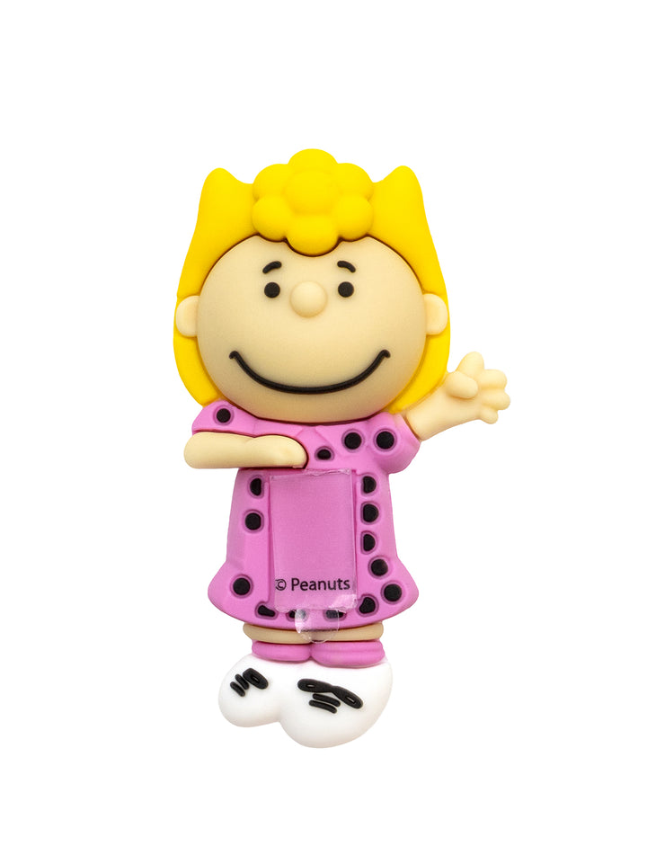 A Peanuts character figure shaped like a smiling girl with yellow hair and a pink polka-dot dress, shown on a plain white background.
