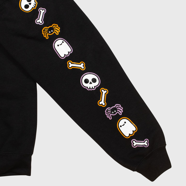 close up of left sleeve. image: repeating pattern of skull, bone, spider, ghost.