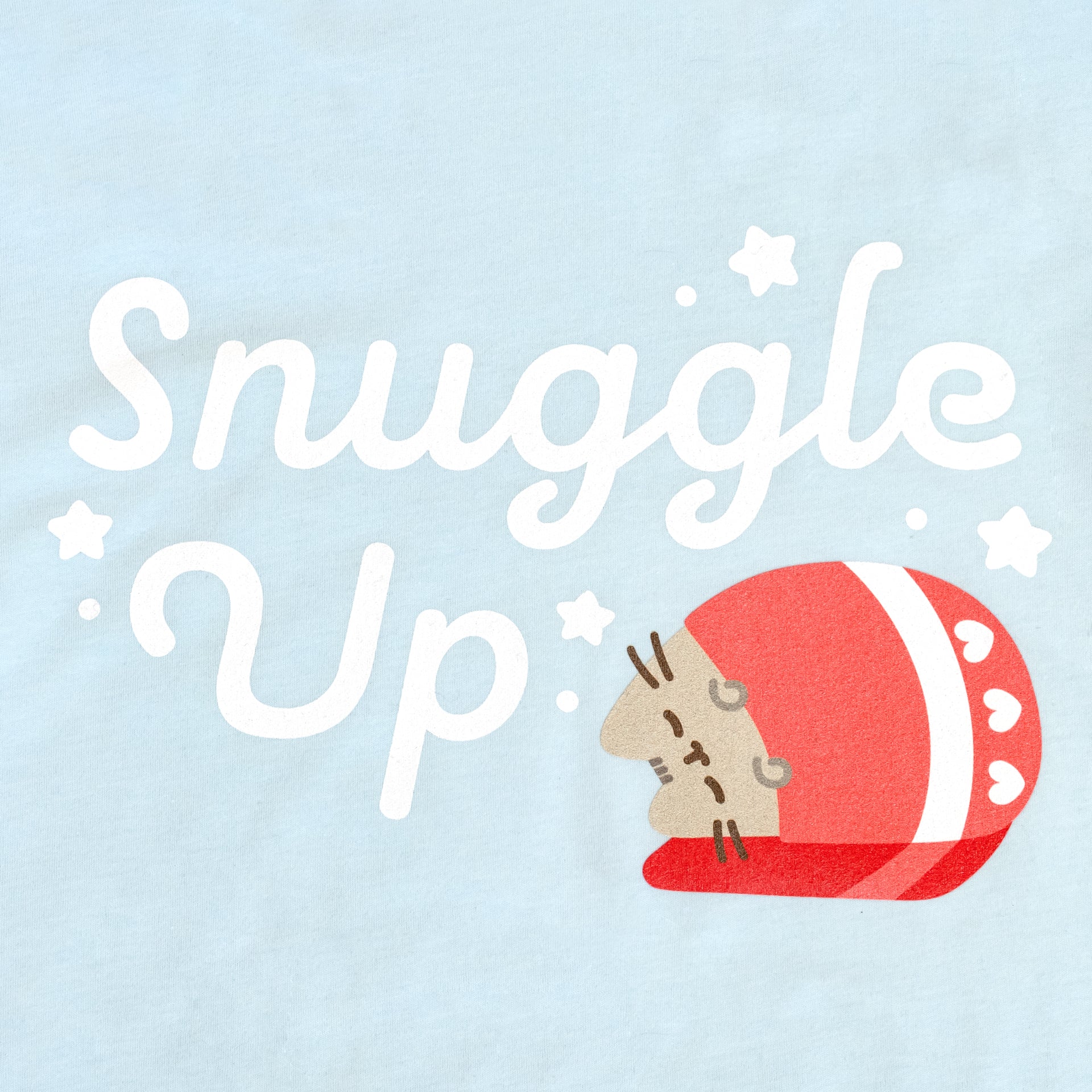 image on shirt: pusheen rolled up in blanket that has hearts on it. stars around. text: snuggle up