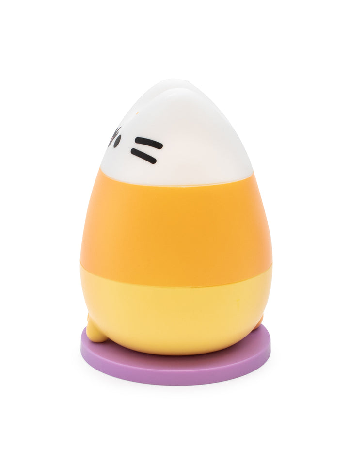 A small egg-shaped figurine with a white top half, yellow middle band, pale yellow bottom half, and a purple circular base, shown on a plain white background.