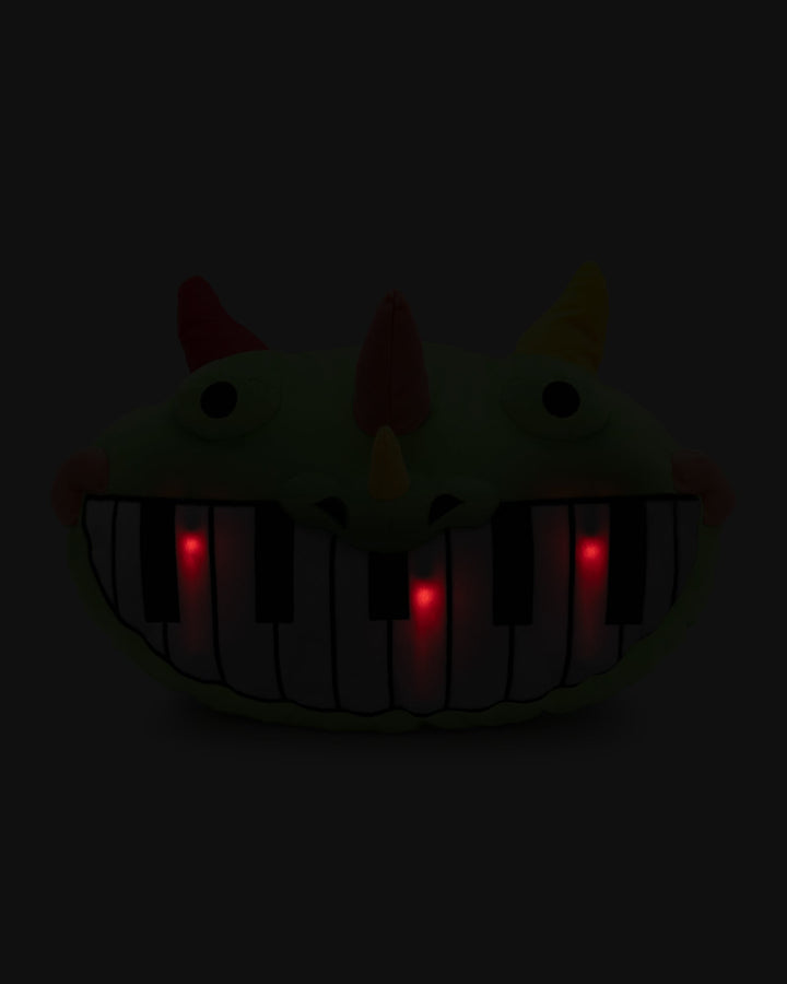 pianosaurus pillow plush in the dark with light up lights on keyboard mouth