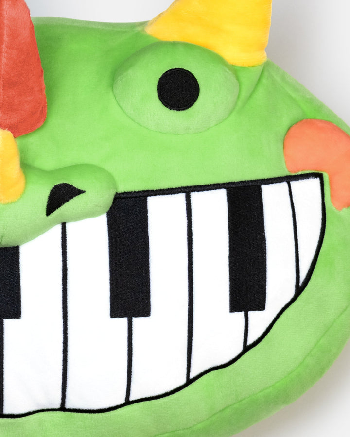 close up of pianosaurus pillow plush