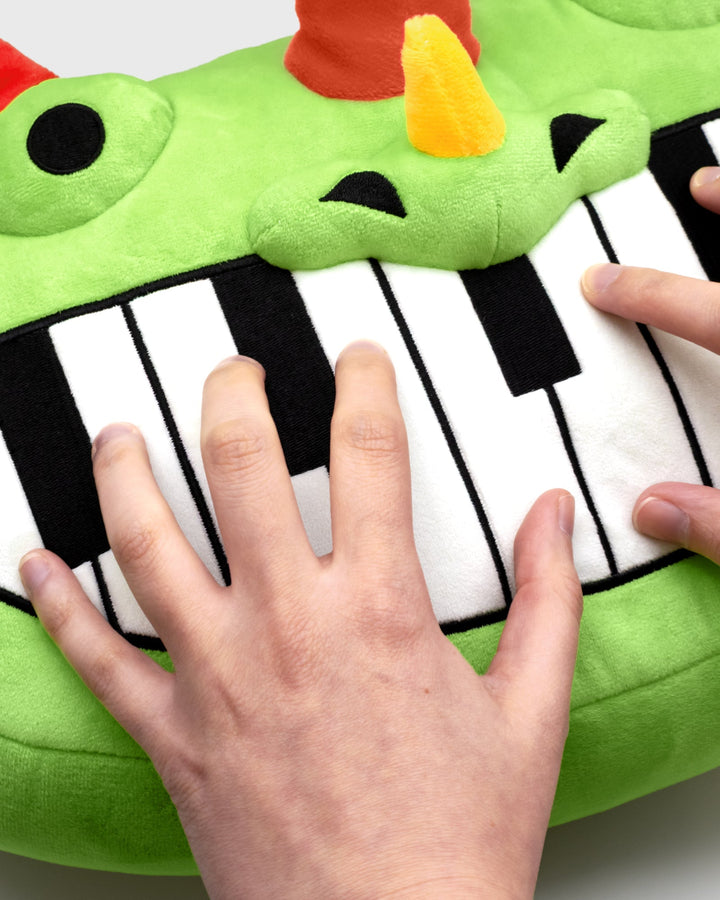 pianosaurus pillow plush being played like piano
