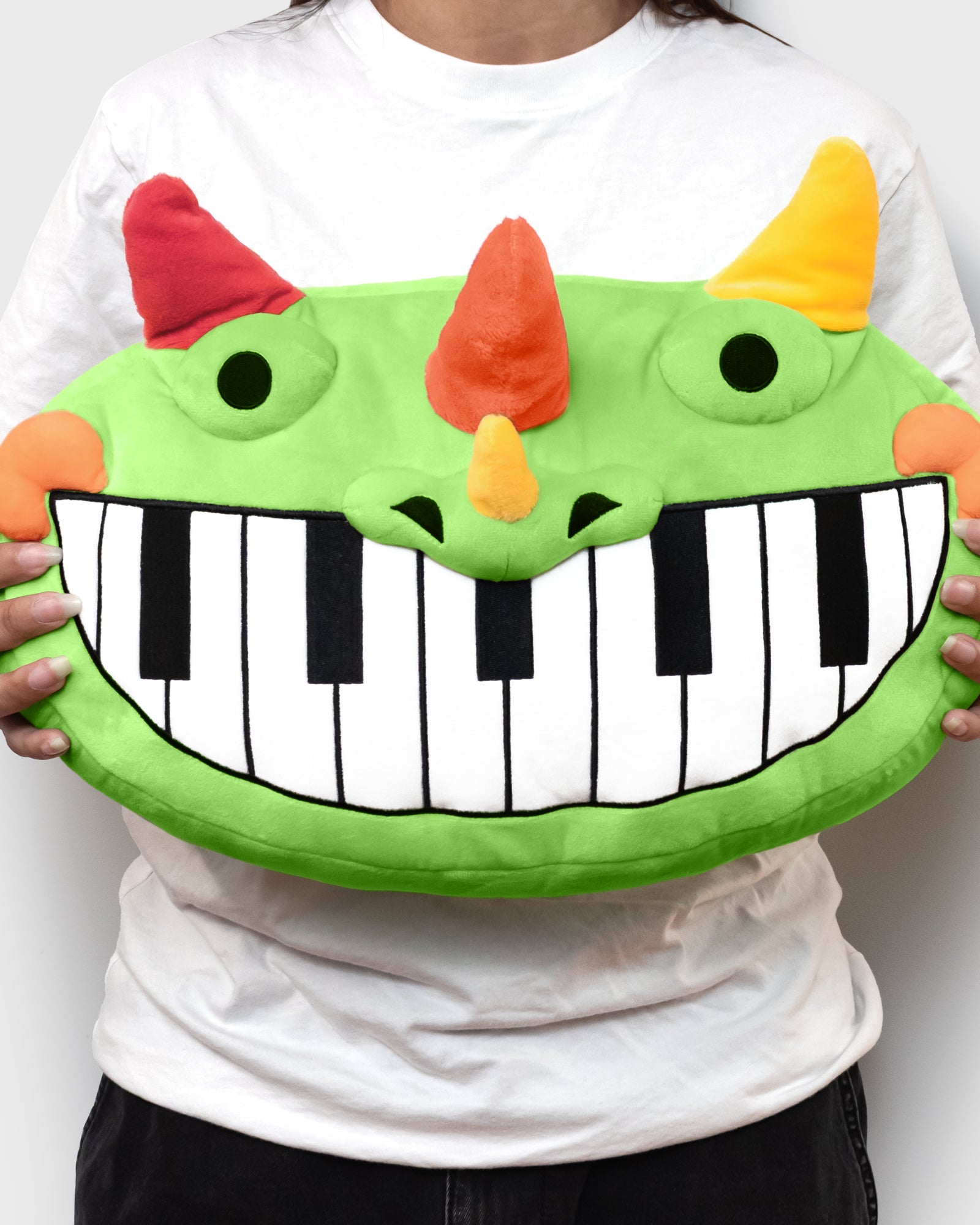 pianosaurus pillow plush being held