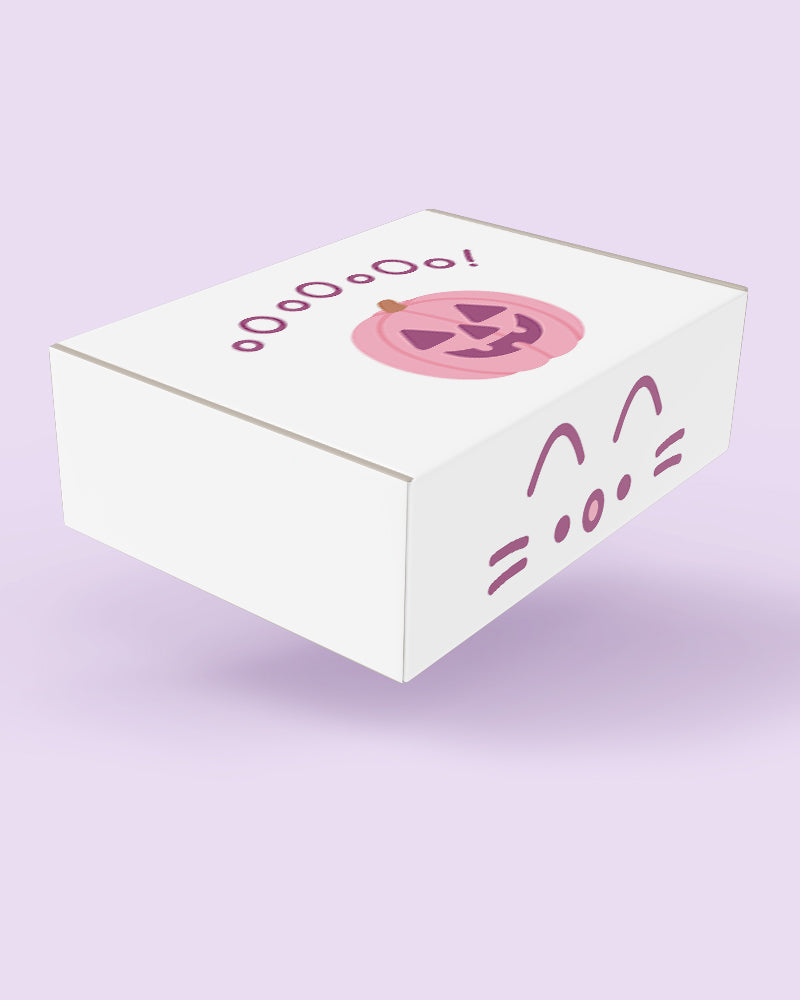 A white rectangular box with pink Halloween-themed illustrations, including a jack-o'-lantern face, the word 'Halloween' in stylized text, and a cat face design on the side, shown on a light lavender background.