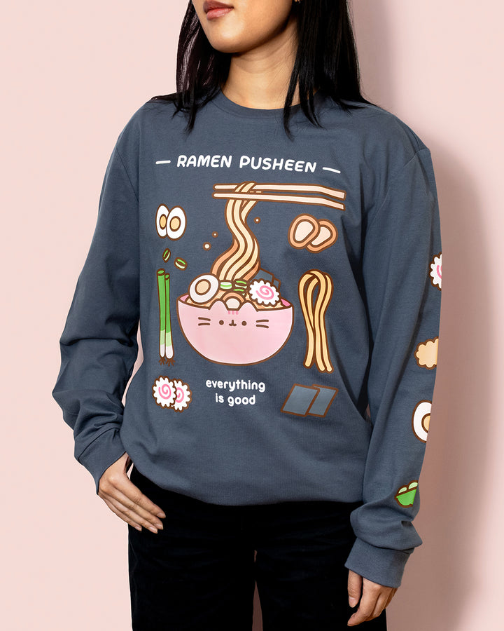 Person wearing a blue sweatshirt with 'Ramen Pusheen' graphic design on a pink background