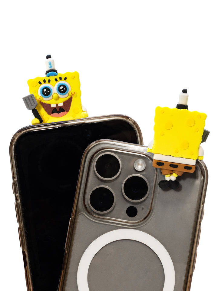 Two clear phone cases with SpongeBob-themed charms attached near the top edges, shown on black smartphones against a plain white background.