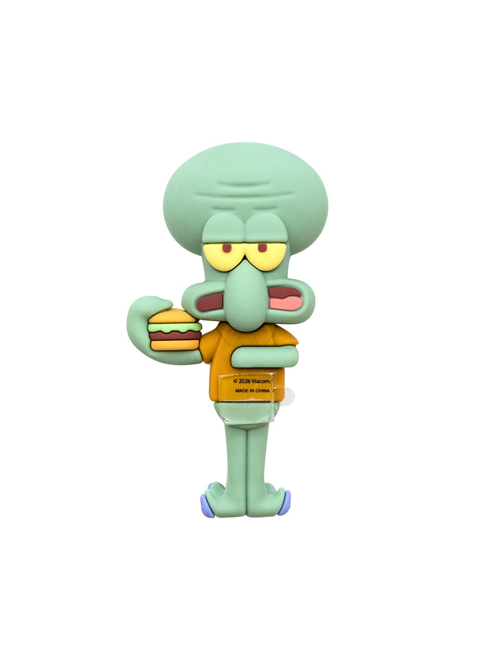 A figurine of Squidward from SpongeBob SquarePants wearing his brown shirt and holding a hamburger, on a solid white background.
