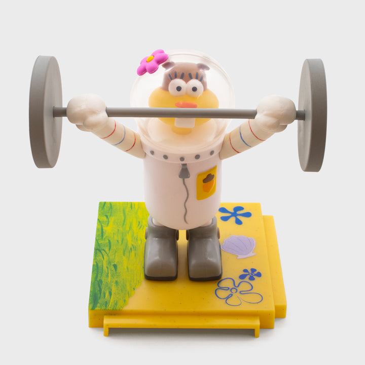 spongebob squarepants vinyl figure. sandy cheeks holding up bar bell on base.