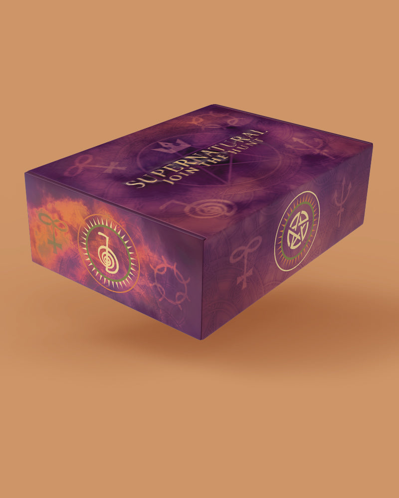 A purple rectangular product box with occult-style symbols and the words 'SUPERNATURAL JOIN THE HUNT' printed on top, shown floating against a warm tan background.