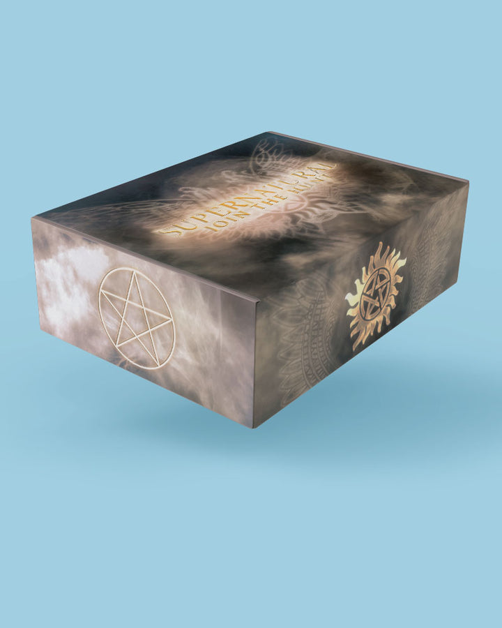 A rectangular product box with a mystical design, featuring a dark smoky background with gold pentagram and sunburst illustrations, shown floating against a solid light blue background.