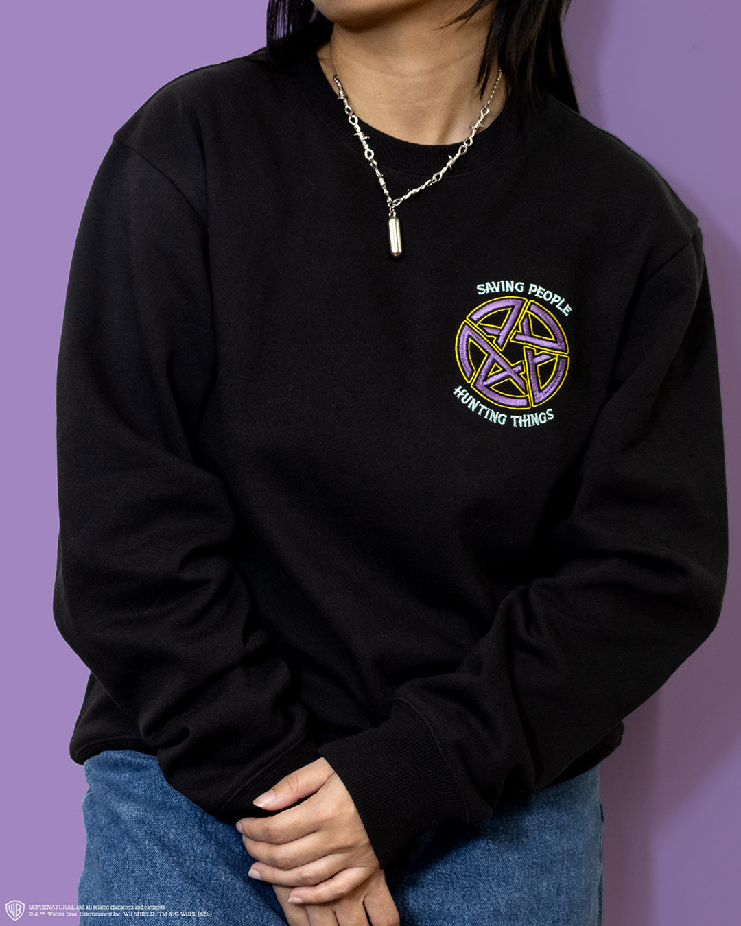 q1 2026 supernatural box crewneck sweater front. image on pocket area: supernatural symbol. text: saving people hunting things.