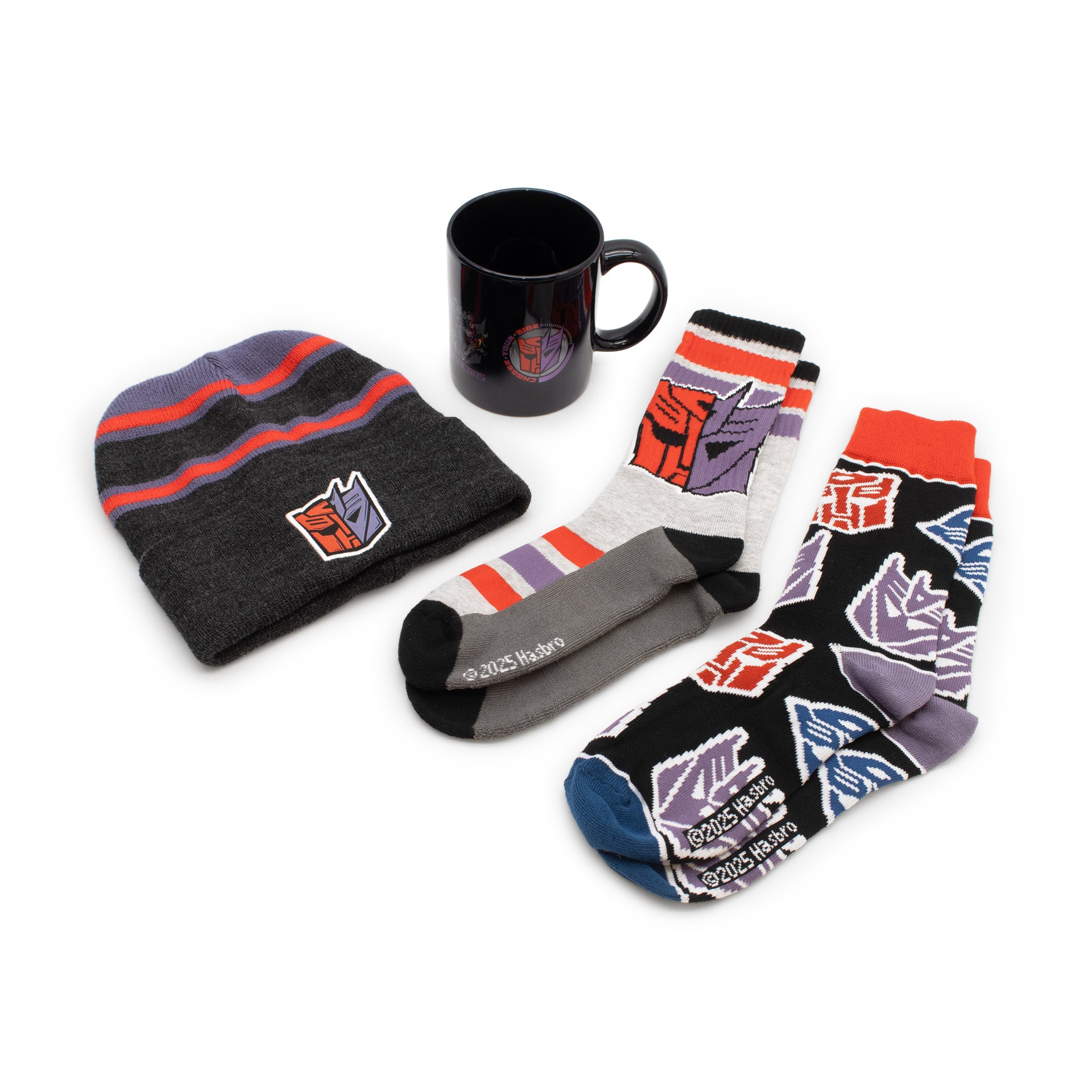 Set of Transformers-themed items including a beanie, socks, and mug on a white background