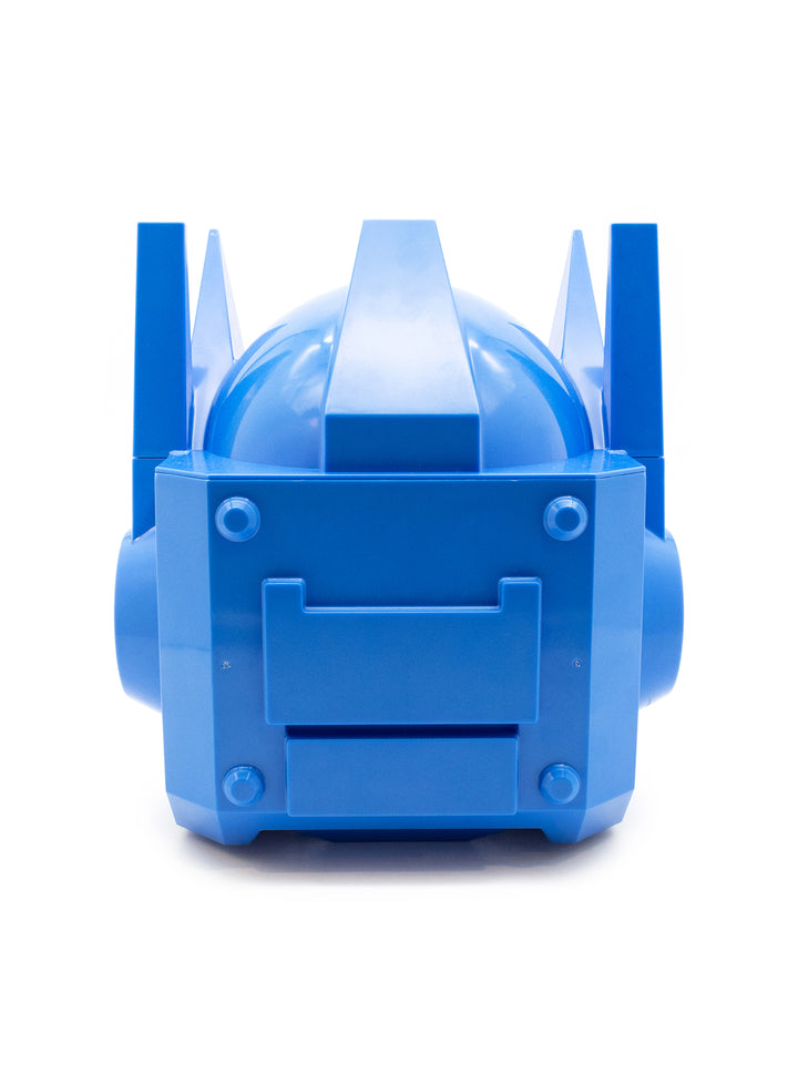 A bright blue plastic toy or model accessory with a rounded dome top, vertical side fins, and a front panel with molded details, photographed on a clean white background.