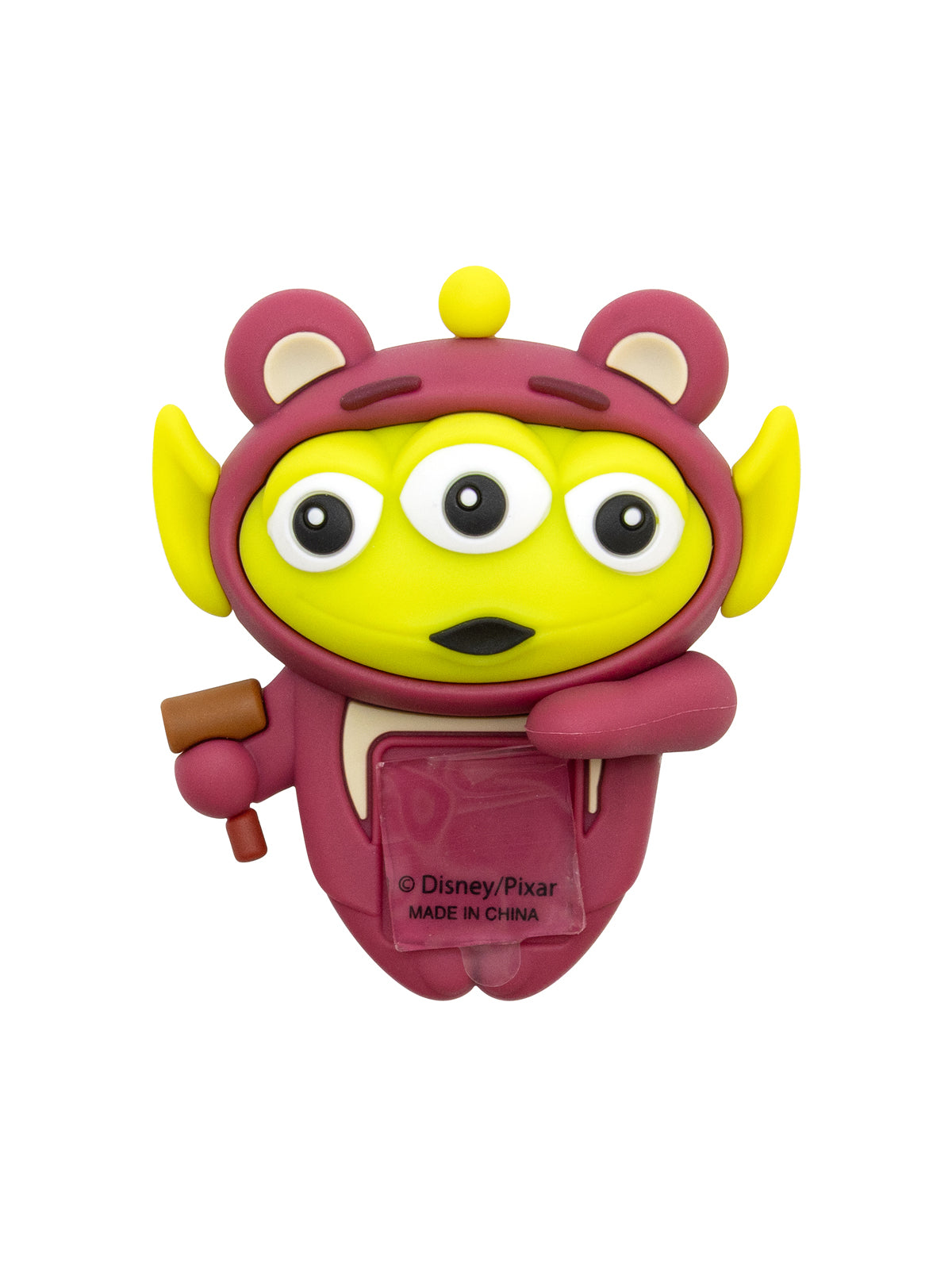 A Disney/Pixar Toy Story Alien figure shaped like the character, featuring a yellow body, pinkish-purple hood and suit, and holding a small brown tool, on a plain white background.