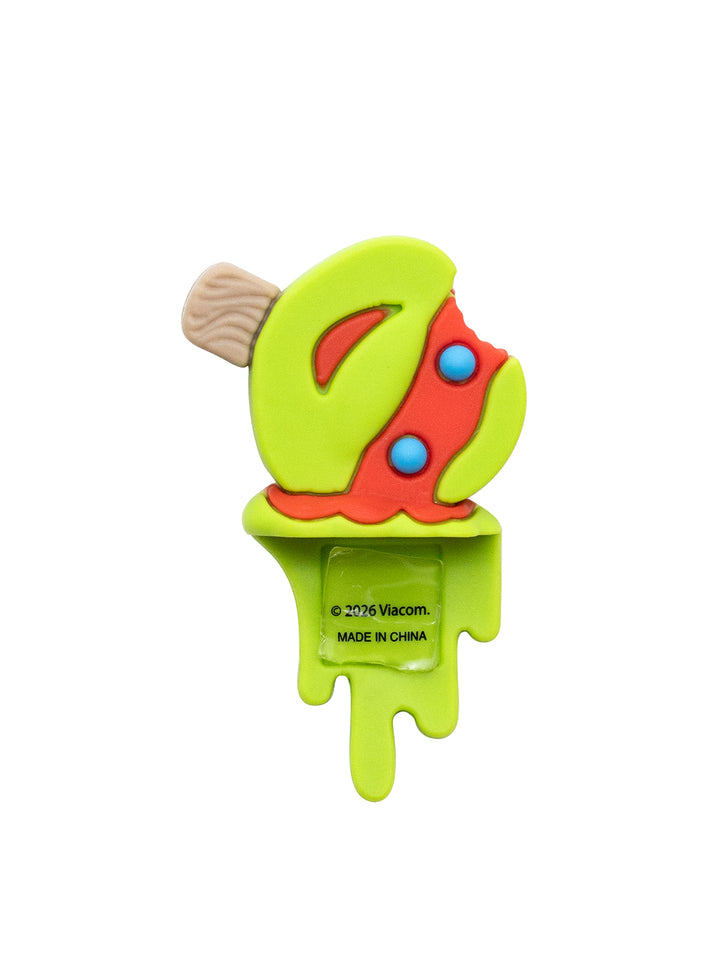 A novelty plastic pop toy shaped like a melting lime green popsicle with red mask, blue dots, and a beige stick, shown on a plain white background.