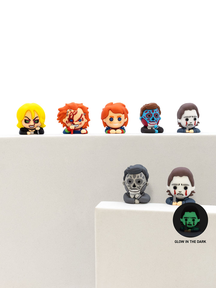 Set of small figurines on a white surface with a dark circle label.