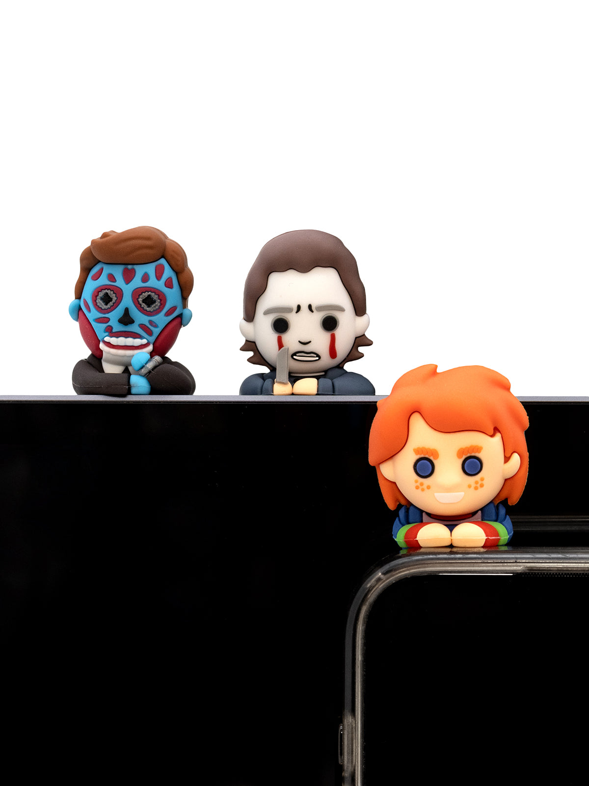 Three colorful figurines on a black surface with a white background