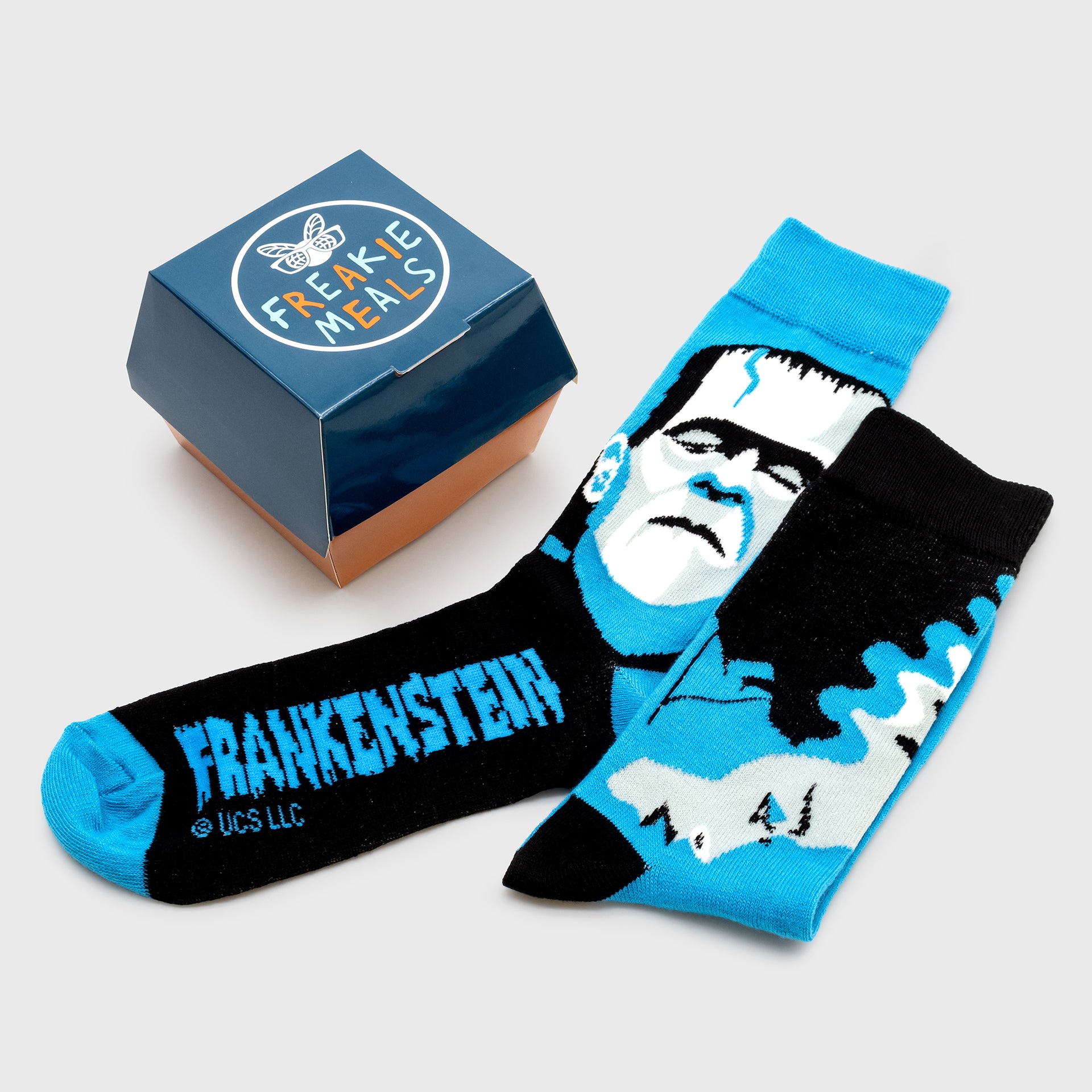 crew socks. image on socks: frankenstein monster on one sock, bride of frankenstein on other sock. text: frankenstein. chicken nugget container for packaging. text on container: freakie meals