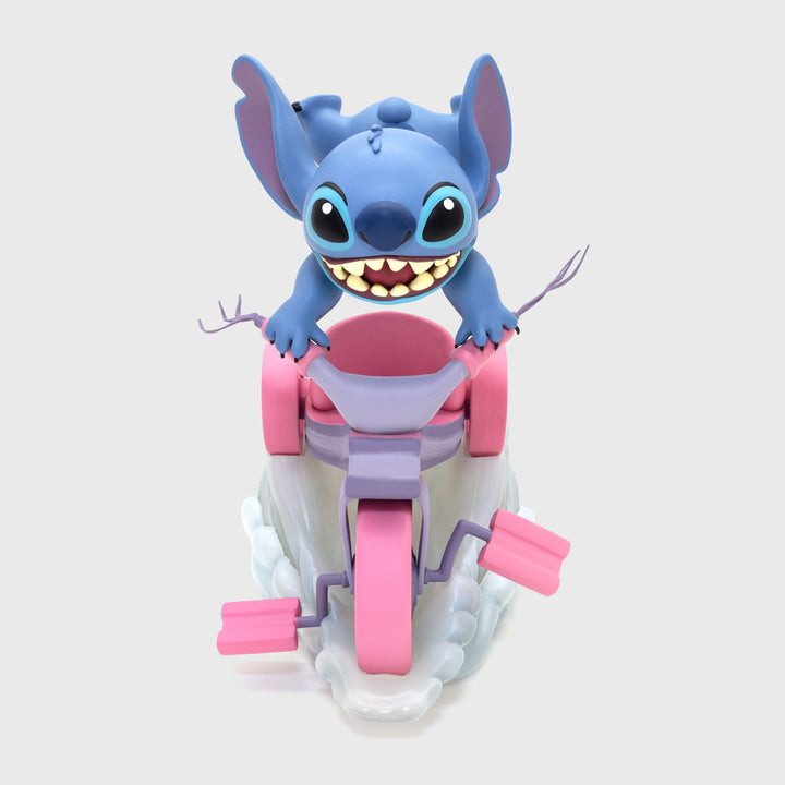 stitch riding on tricycle facing forward.